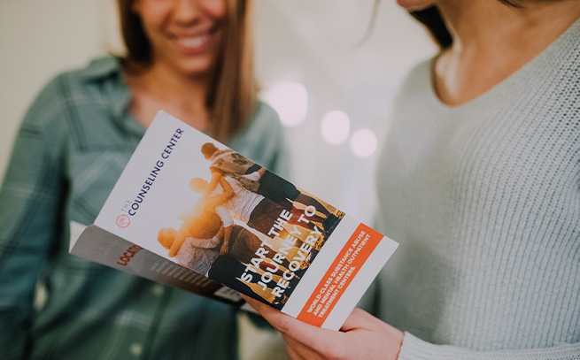 Two ladies reading a brochure at a counseling center hallway