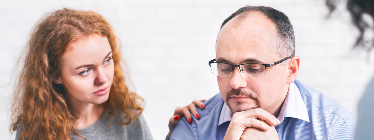  Supportive wife comforting husband with TRD during a meeting with a counselor.
