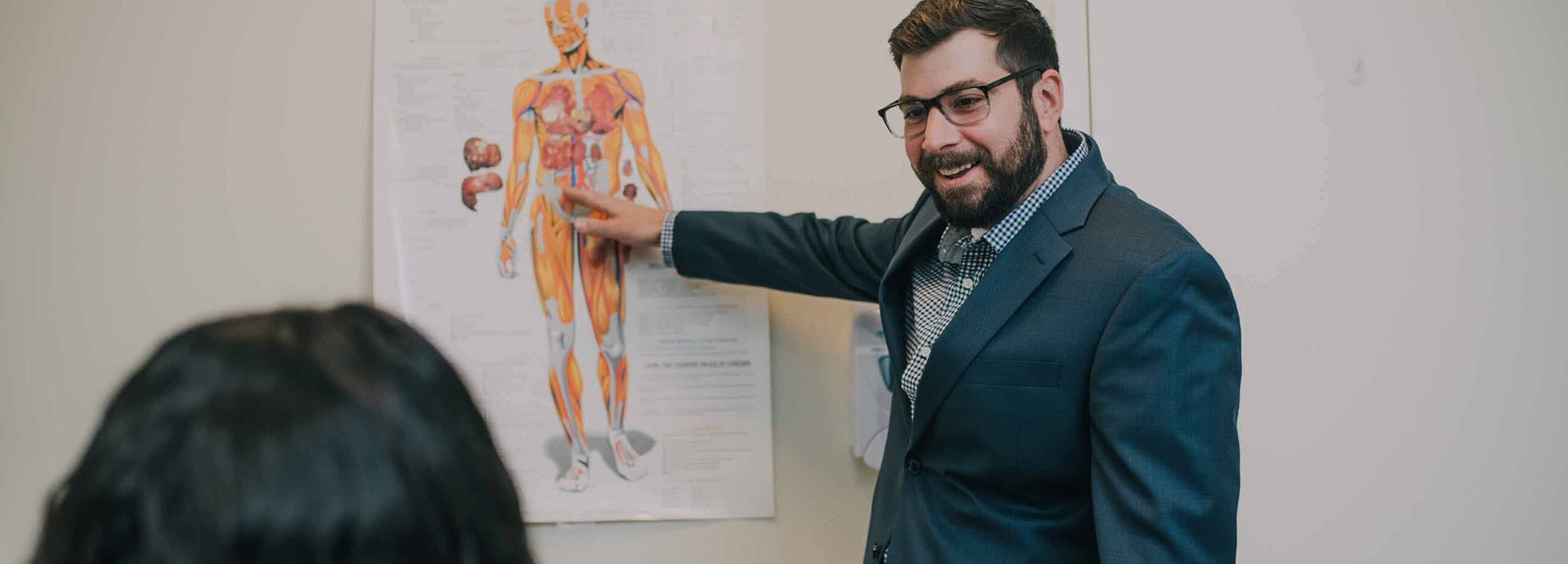 man pointing at an exhibit teaching a class
