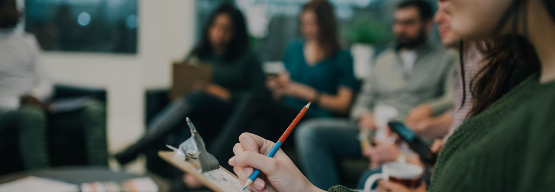 close up of someone writing on note pad in group consoling